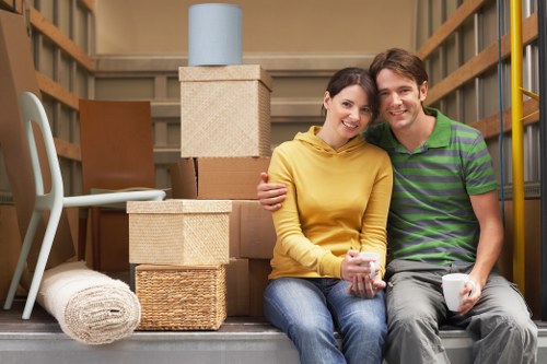 Professional movers loading wrapped furniture into a removal van