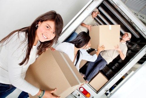Professional movers carrying household items in Chiswick